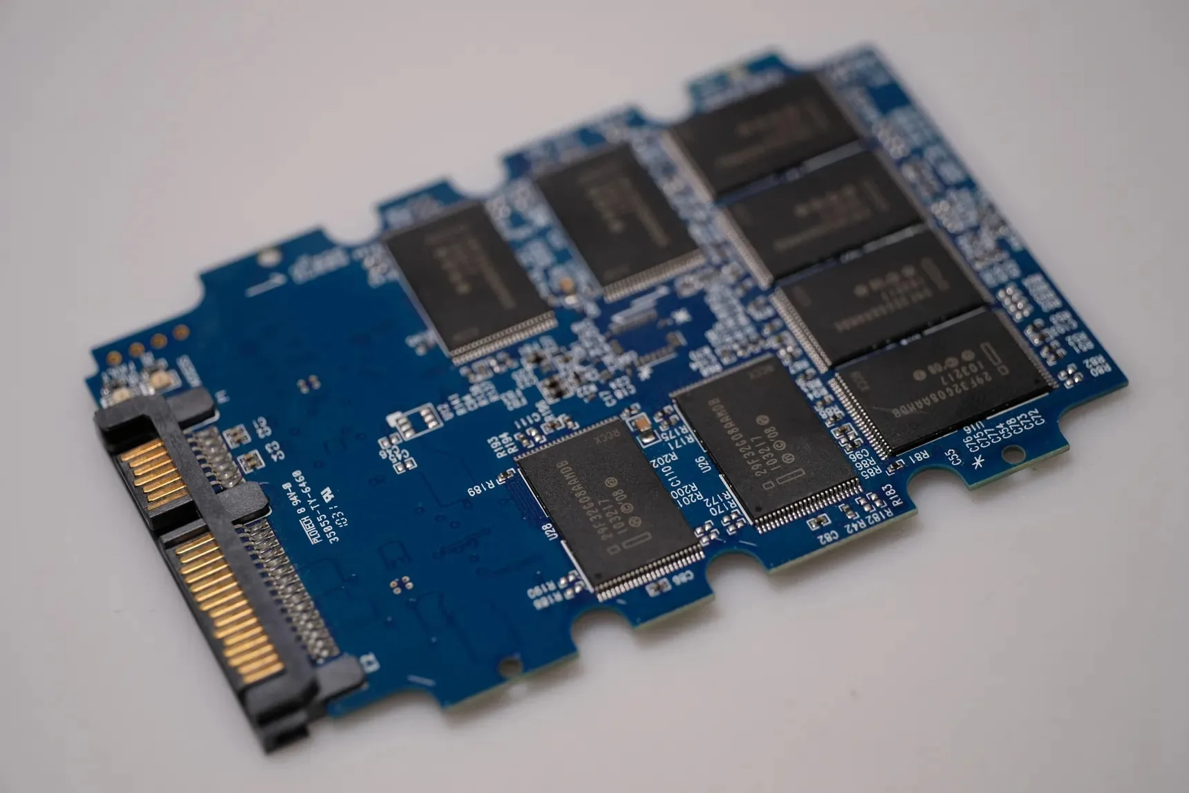 Detail desky SSD disku s NAND flash čipy a SATA konektorem